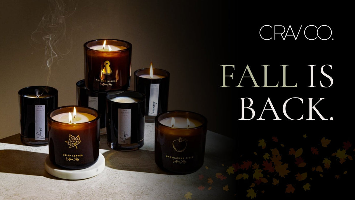 CRAV Co. Fall Collection candles in Autumn Nights, Crisp Leaves, and Madagascar Cider, lit beside Fall Is Back text